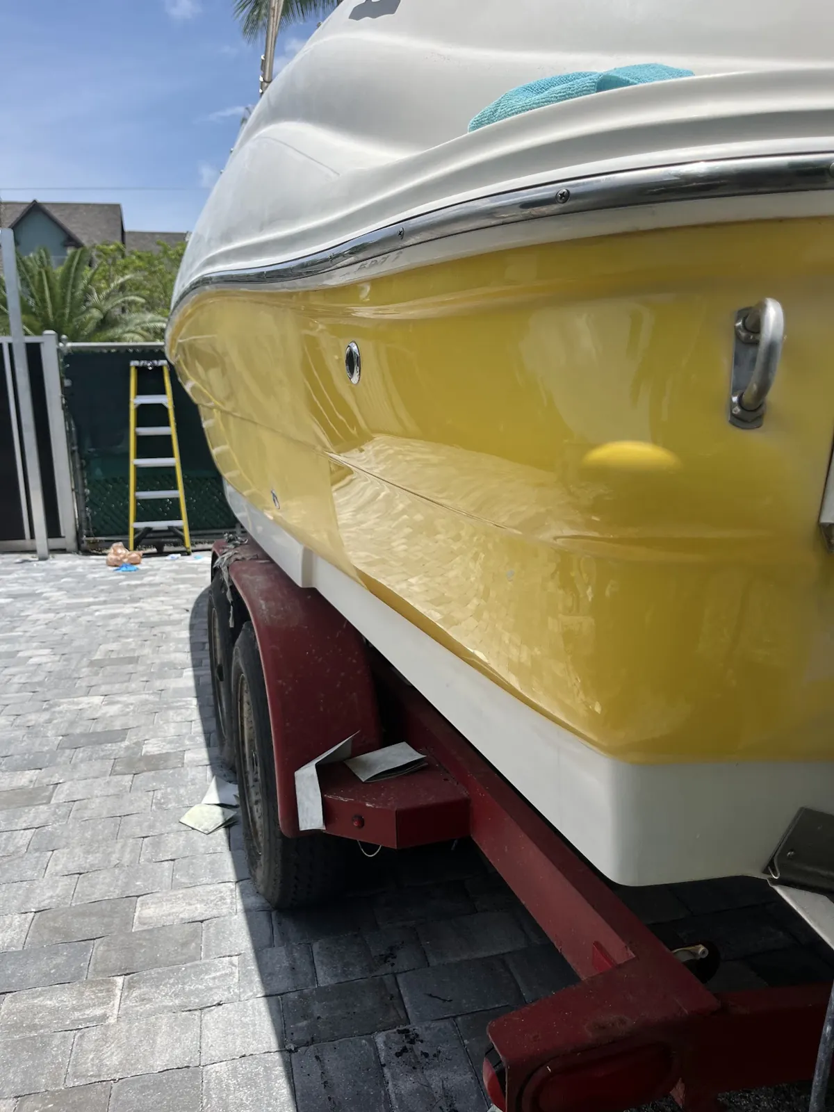 Yellow boat hull on a trailer off Berkeley Street in Boca Raton after a full restoration with wet and dry sanding and polish