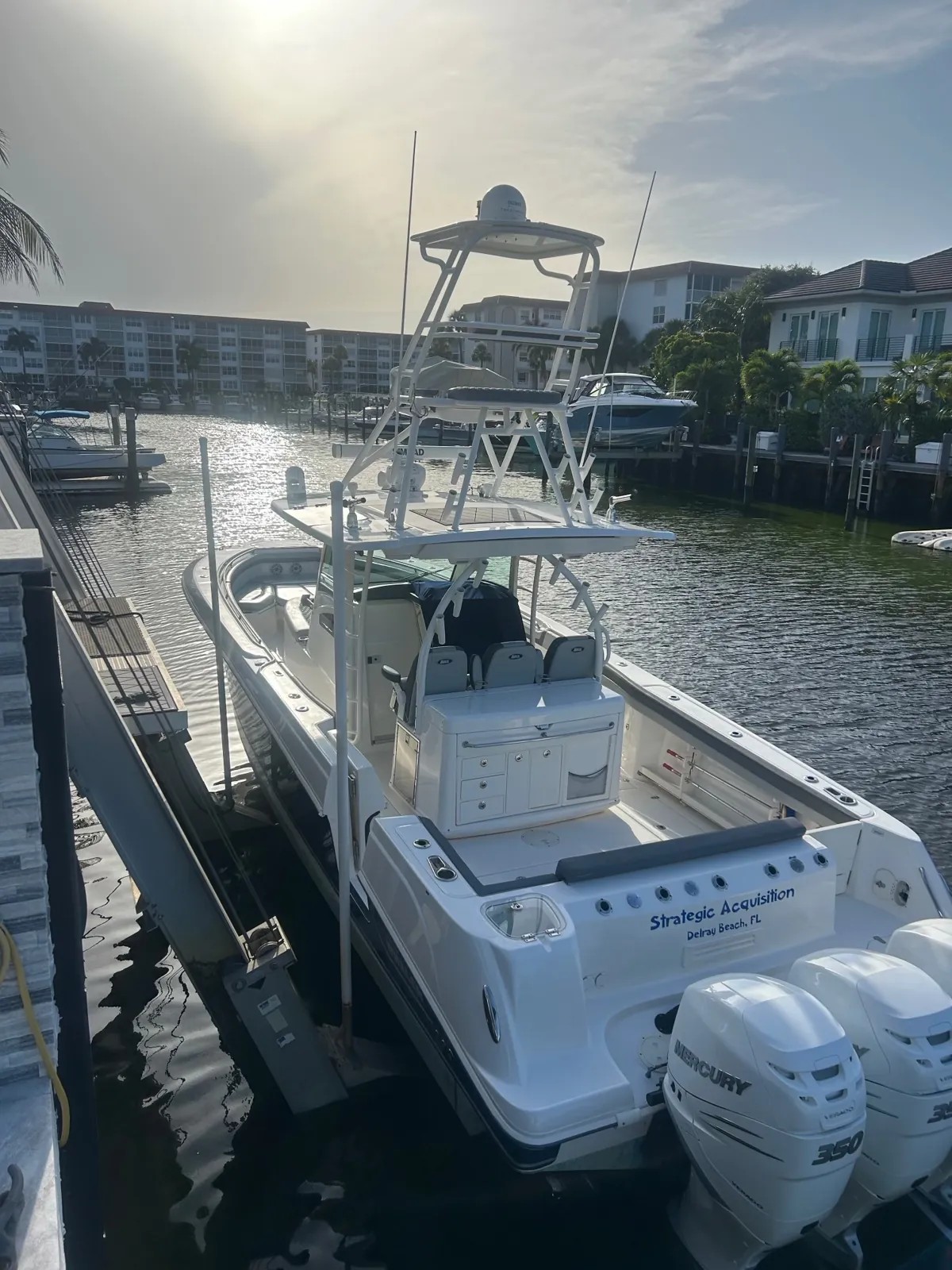Center console with a tuna tower on a boat lift in a Delray Beach canal, kept free of black streaks on a recurring wash plan