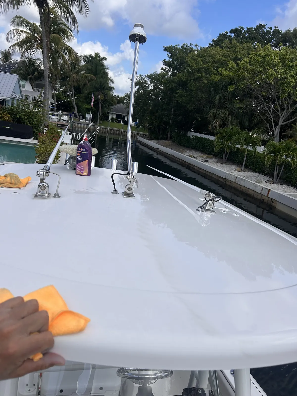 White boat hardtop being compounded with 3M heavy compound beside a canal in Fort Lauderdale, Florida