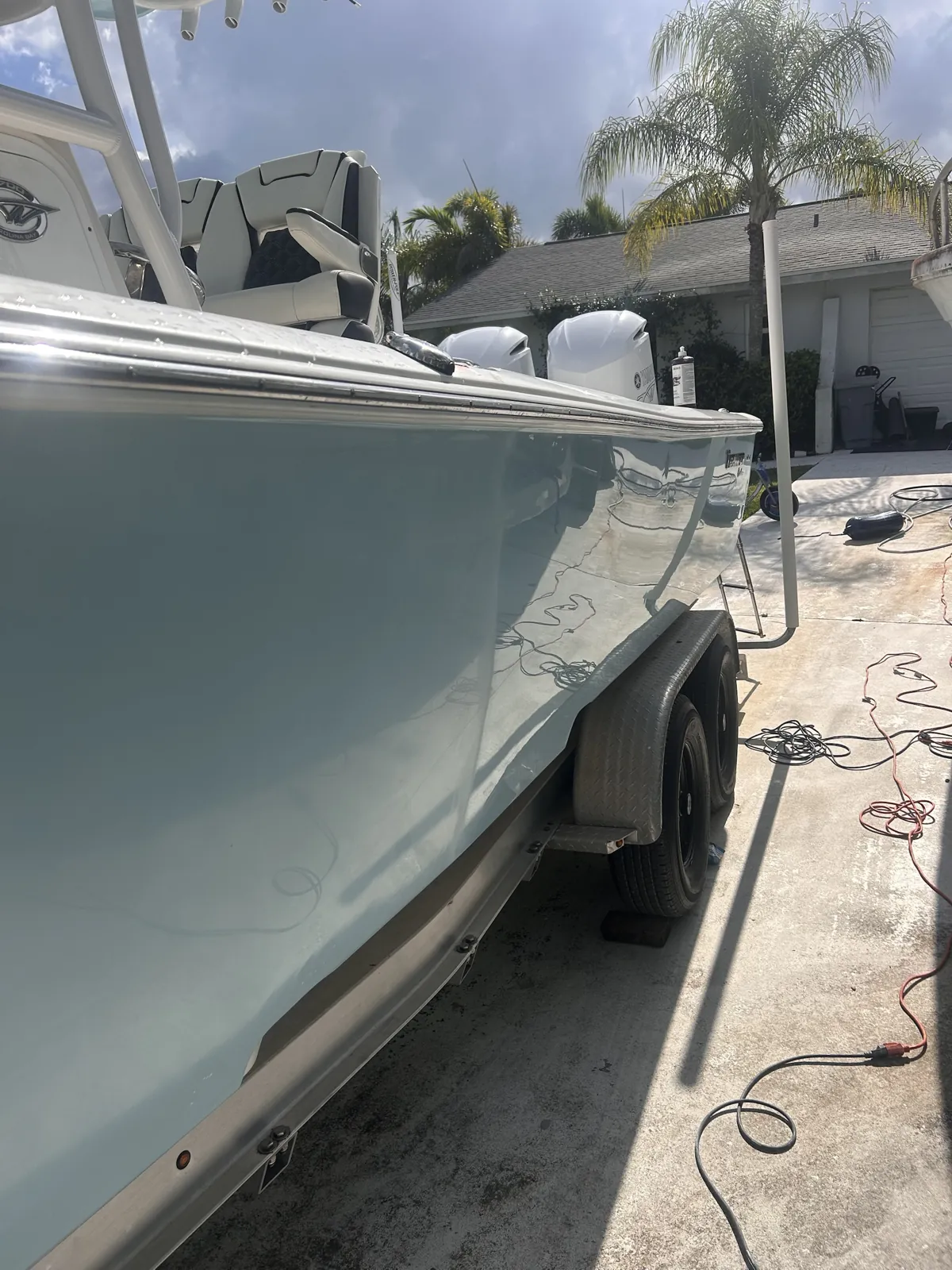 Pale blue boat hull on a trailer polished to a mirror finish in Jupiter Farms, Florida