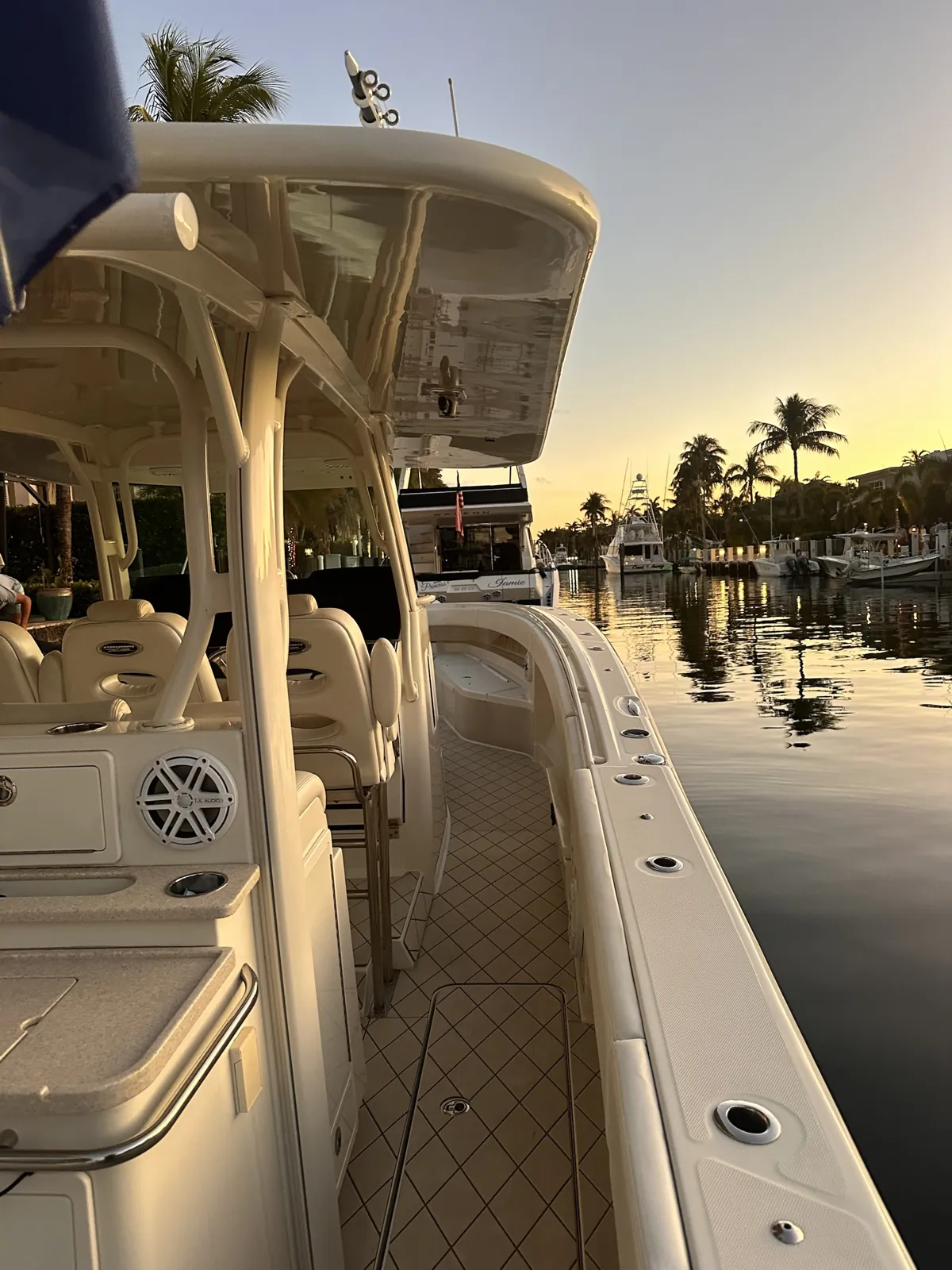 Clean cream center console tied up on a canal at sunset in Lighthouse Point, Florida