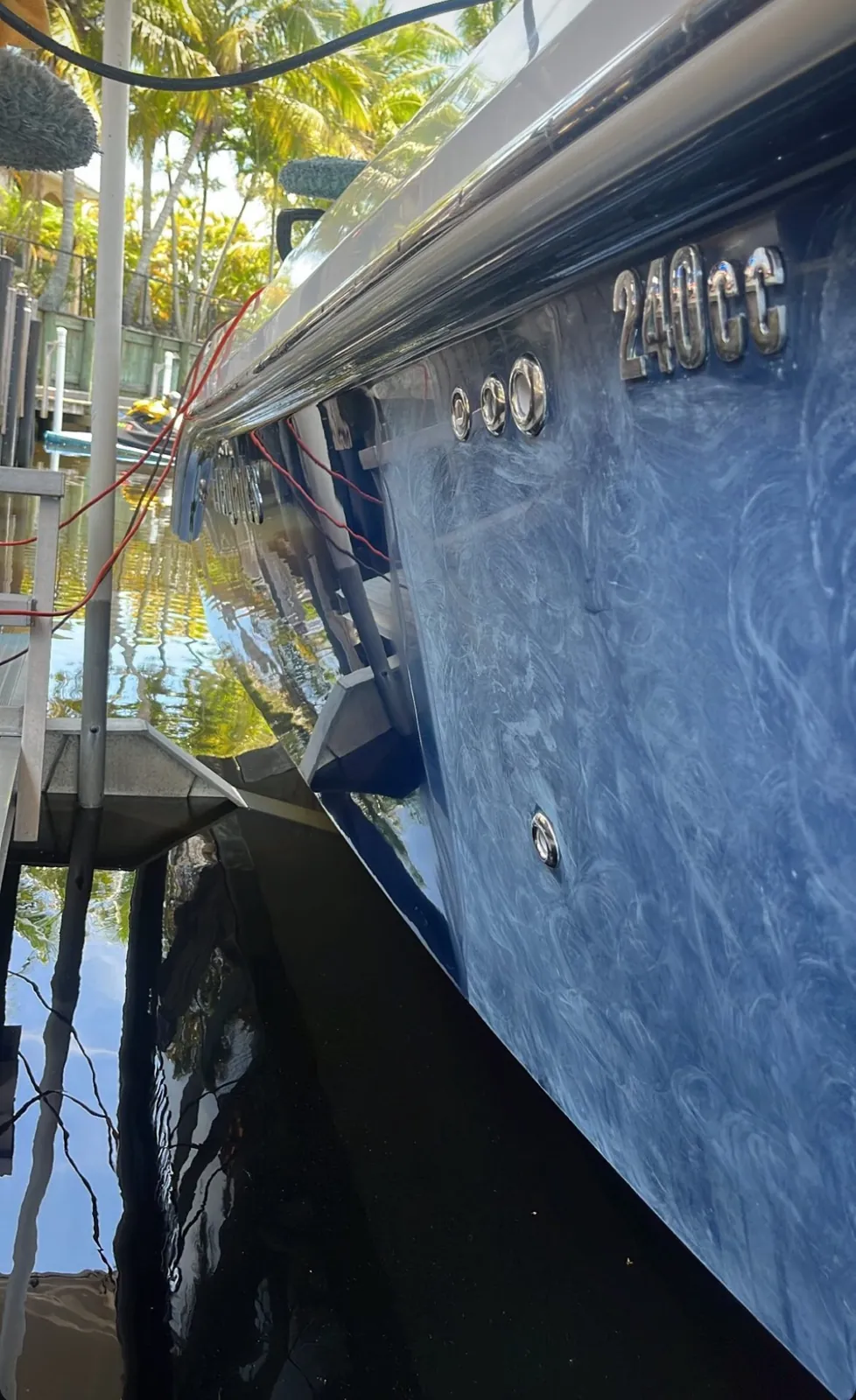 Blue 240CC boat hull at a small waterfront community in west Boca Raton, restored with wet and dry sanding to a deep gloss